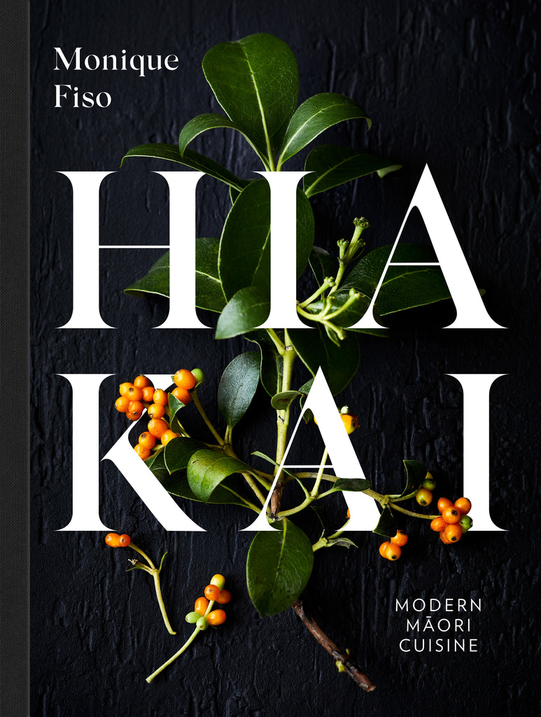 Front cover of the book featuring the word Hiakai in large font intertwined with a piece of foliage on a black wood grain background