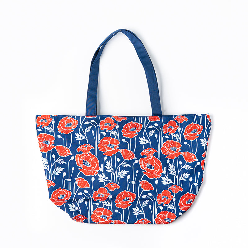 A royal blue beach bag features a poppy design in red and white