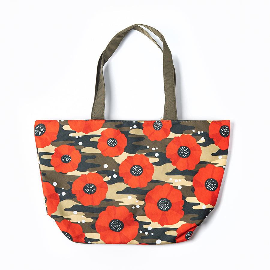 A beach bag features bright red poppies against a green camouflage background