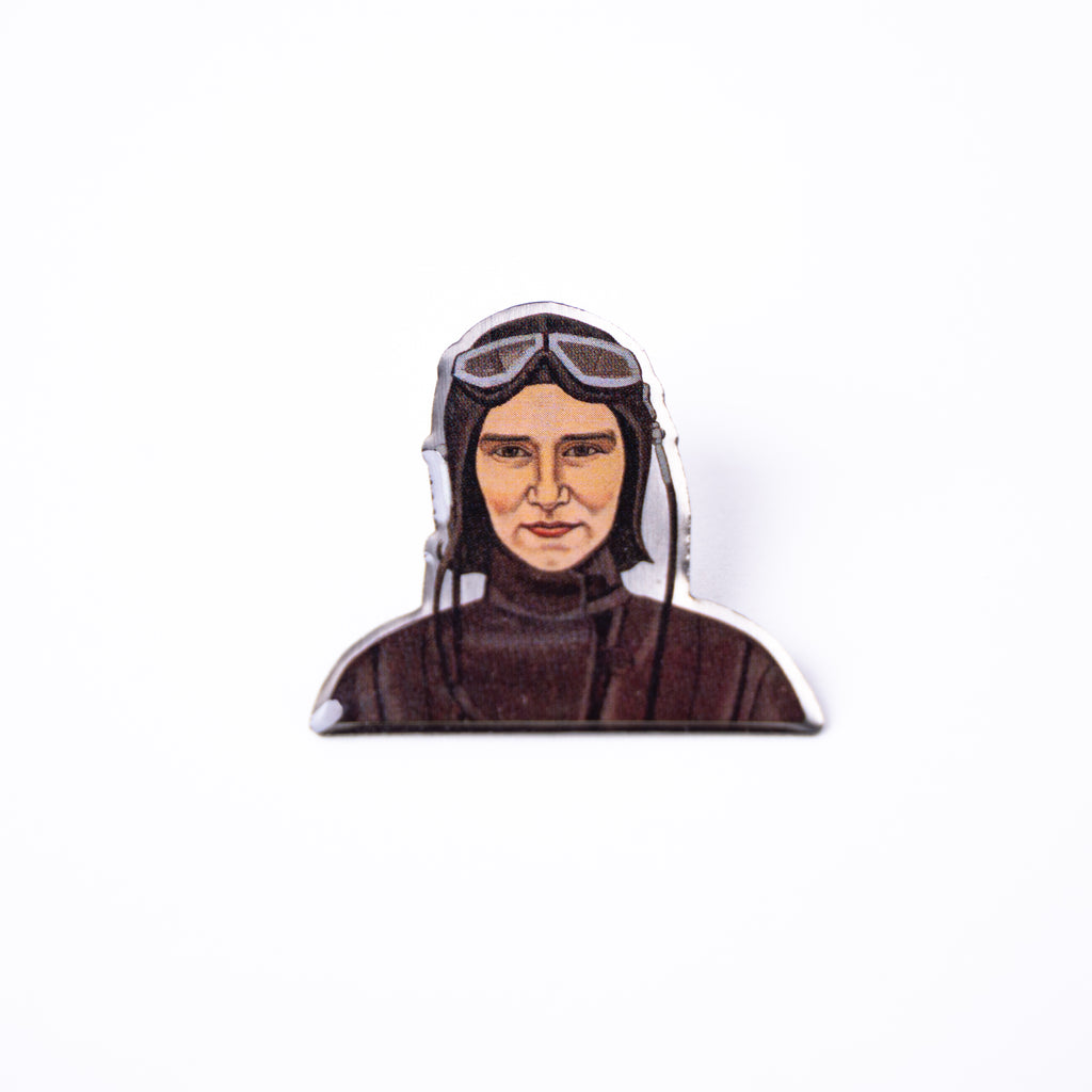 A small pin featuring a woman wearing old-fashioned aviation clothing and goggles